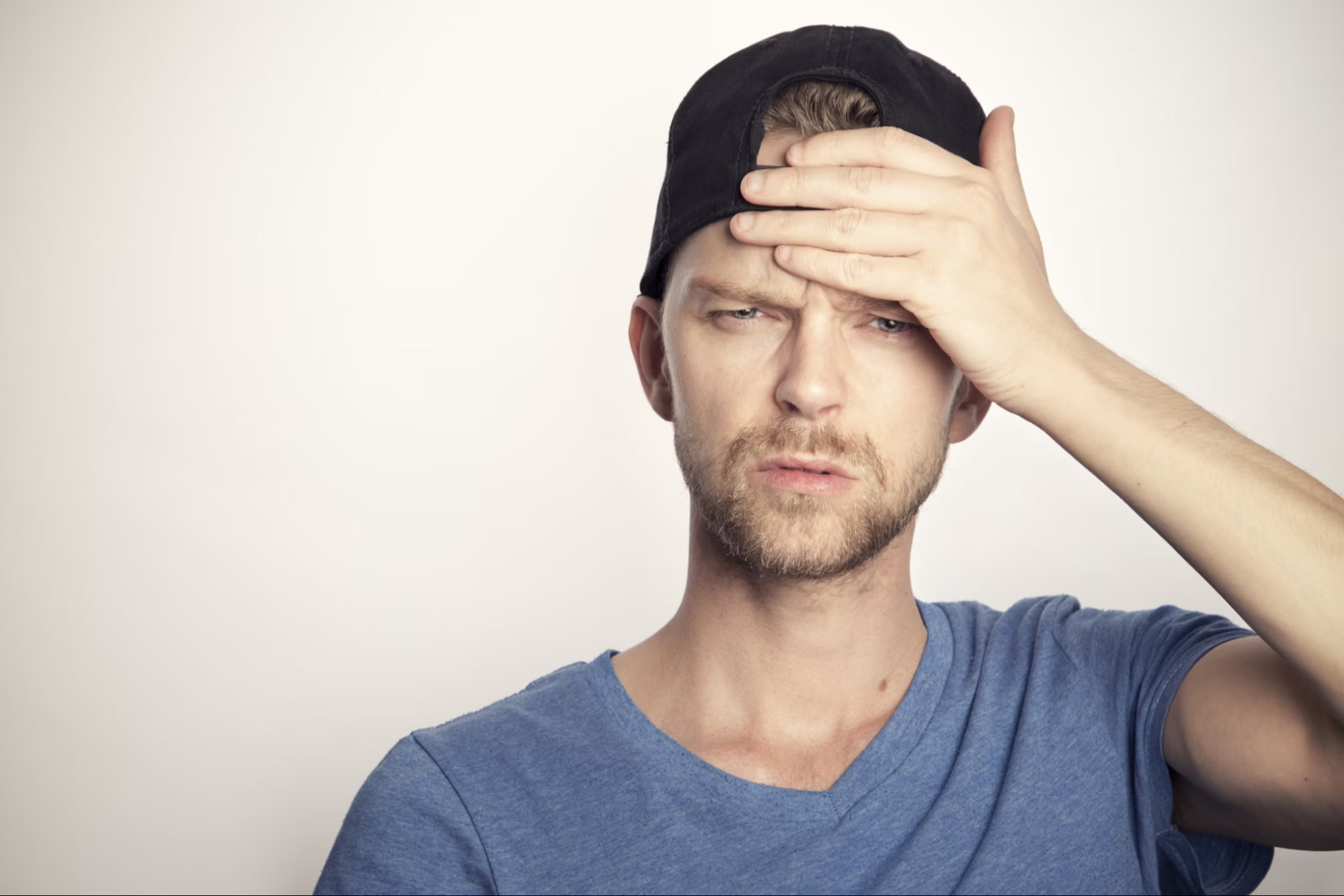 Man holding his head in discomfort, experiencing a headache, a common symptom of Carbon Monoxide poisoning.