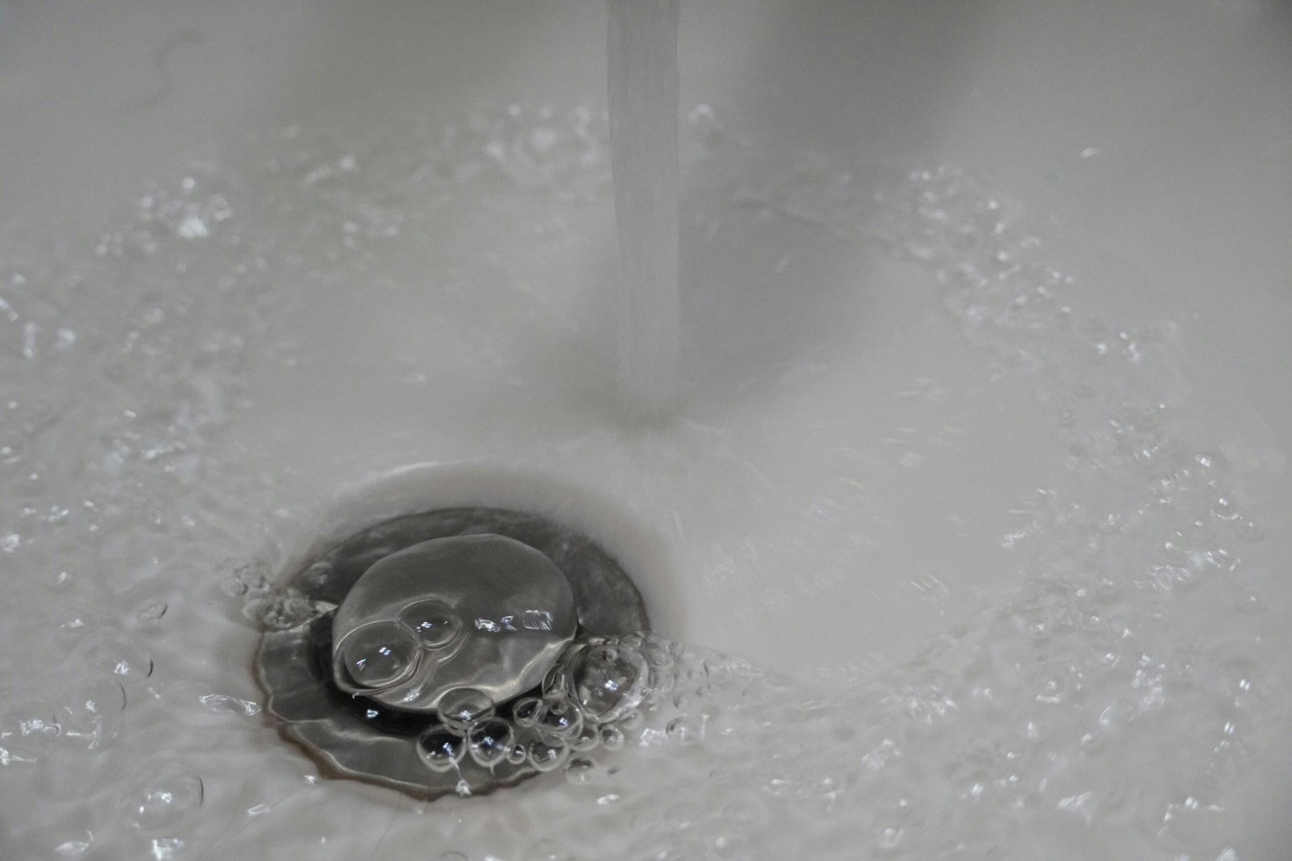 A close up of a sink with hot water running down it.